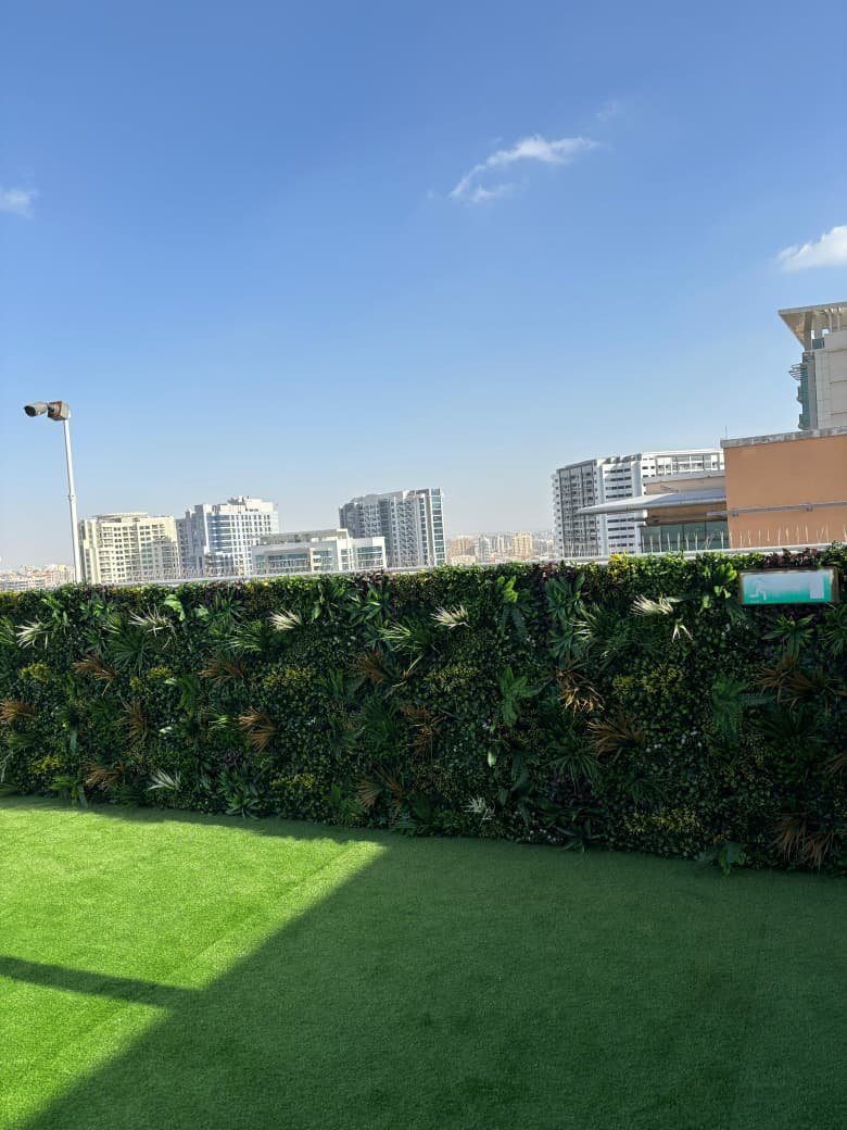 Custom green wall installation with Dubai skyline backdrop