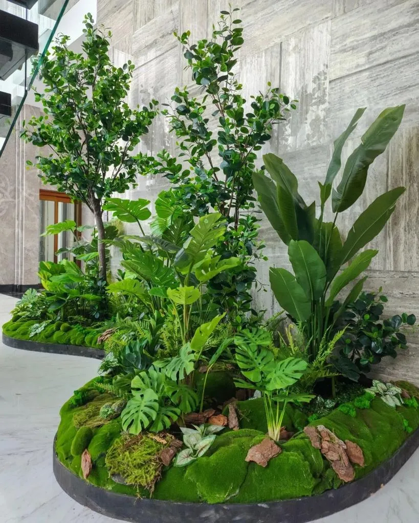 Real completed project: moss-base planter island with trees and tropical foliage in an office lobby